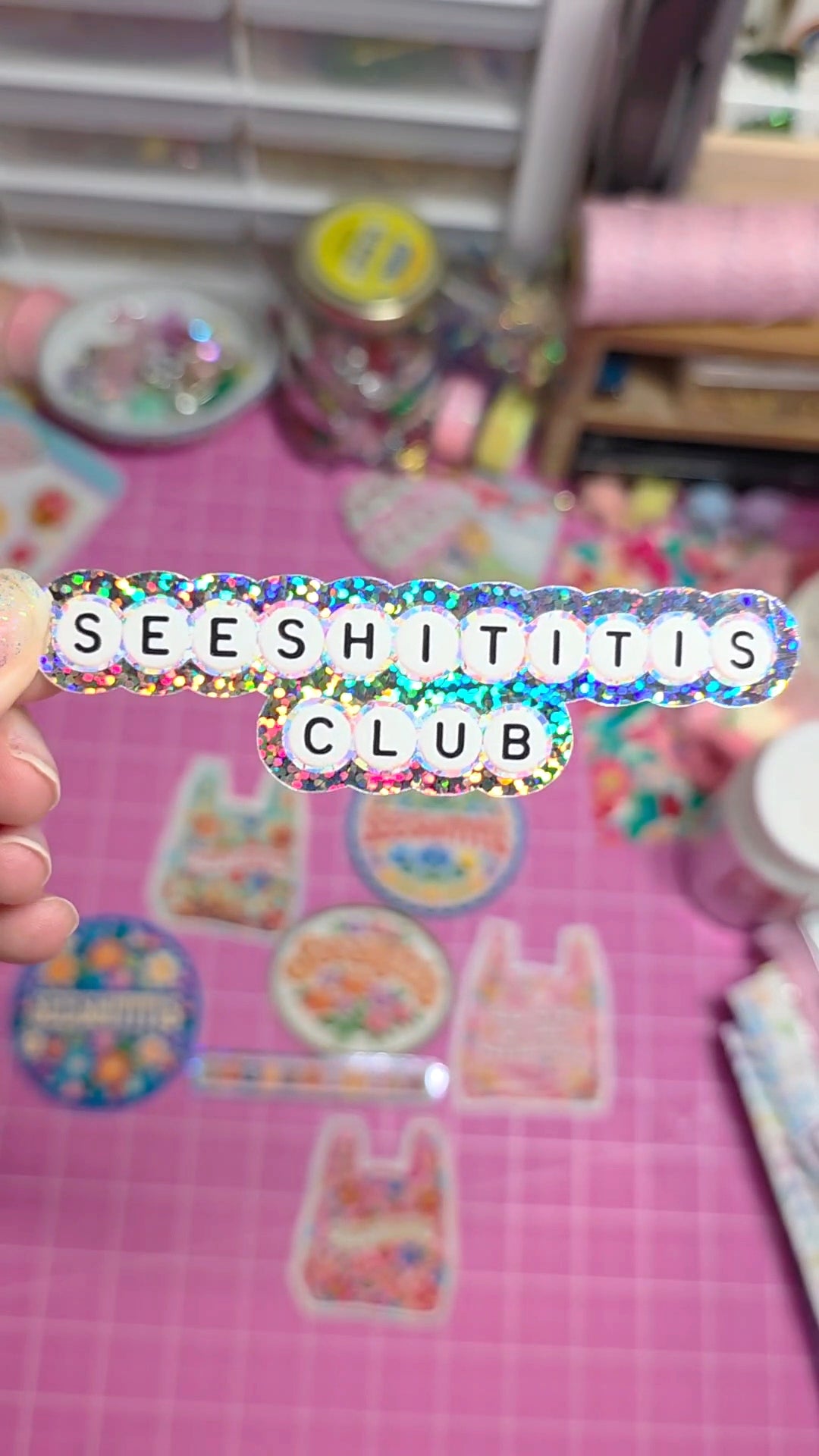 Colorful stickers on a pink surface with 'SEESHITITIS CLUB' text overlay.