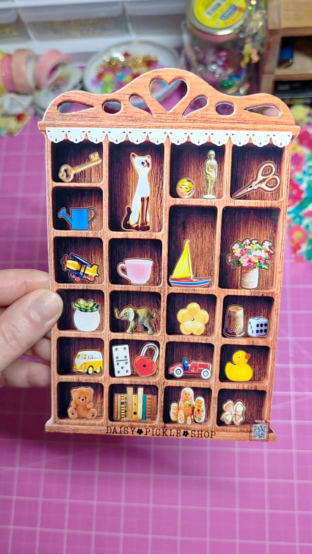 Wooden toy shop with miniature items on a pink grid background