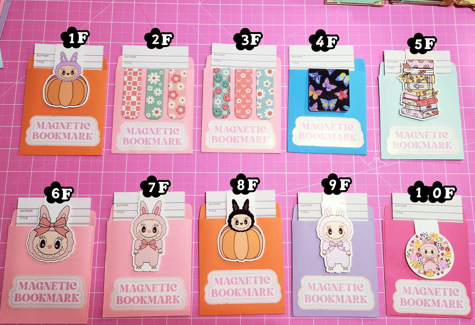 Set of magnetic bookmarks with various designs on a pink grid background