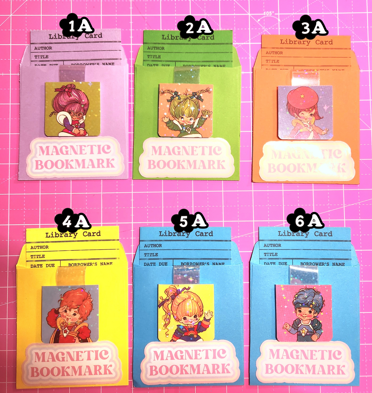 Set of magnetic bookmarks with various designs on a pink grid background