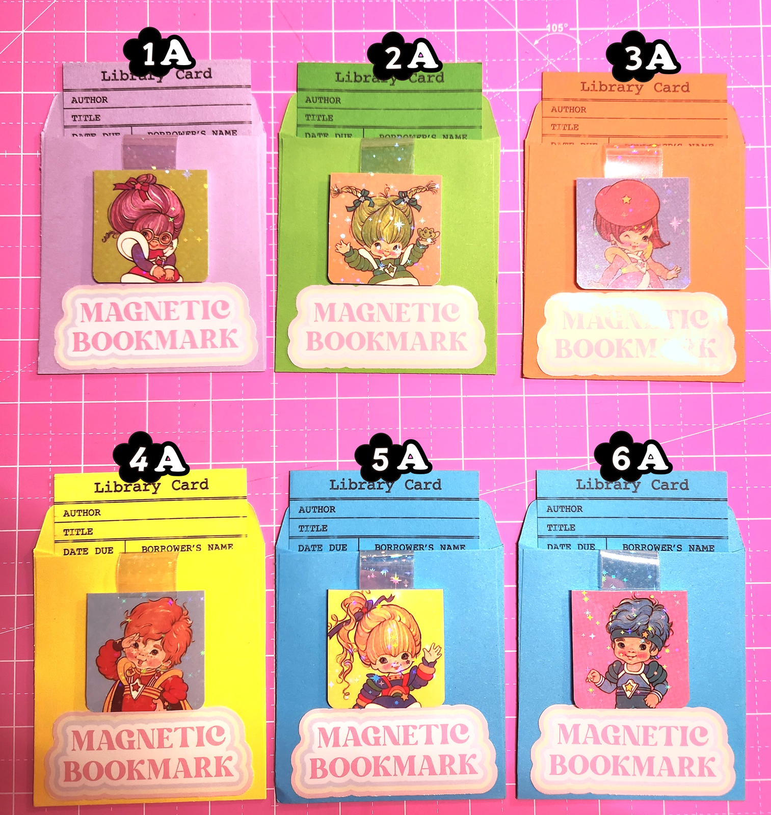 Set of magnetic bookmarks with various designs on a pink grid background